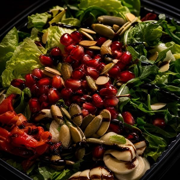 Fresh salad with pomegranate seeds and balsamic drizzle